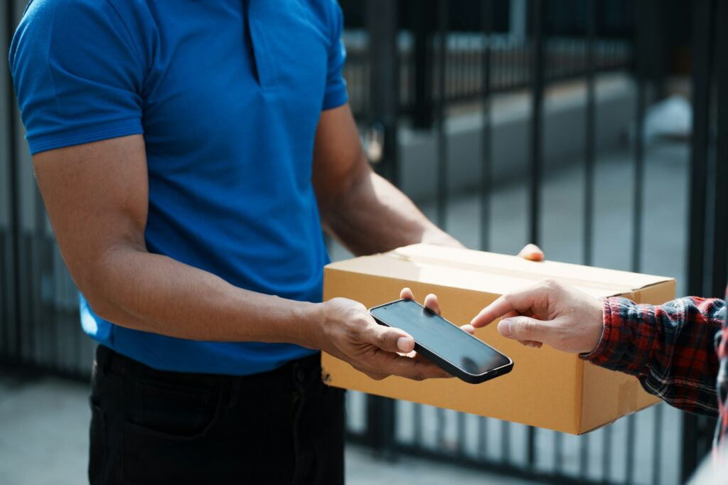 A man delivers a package to another individual, showcasing a moment of exchange and assistance between them.