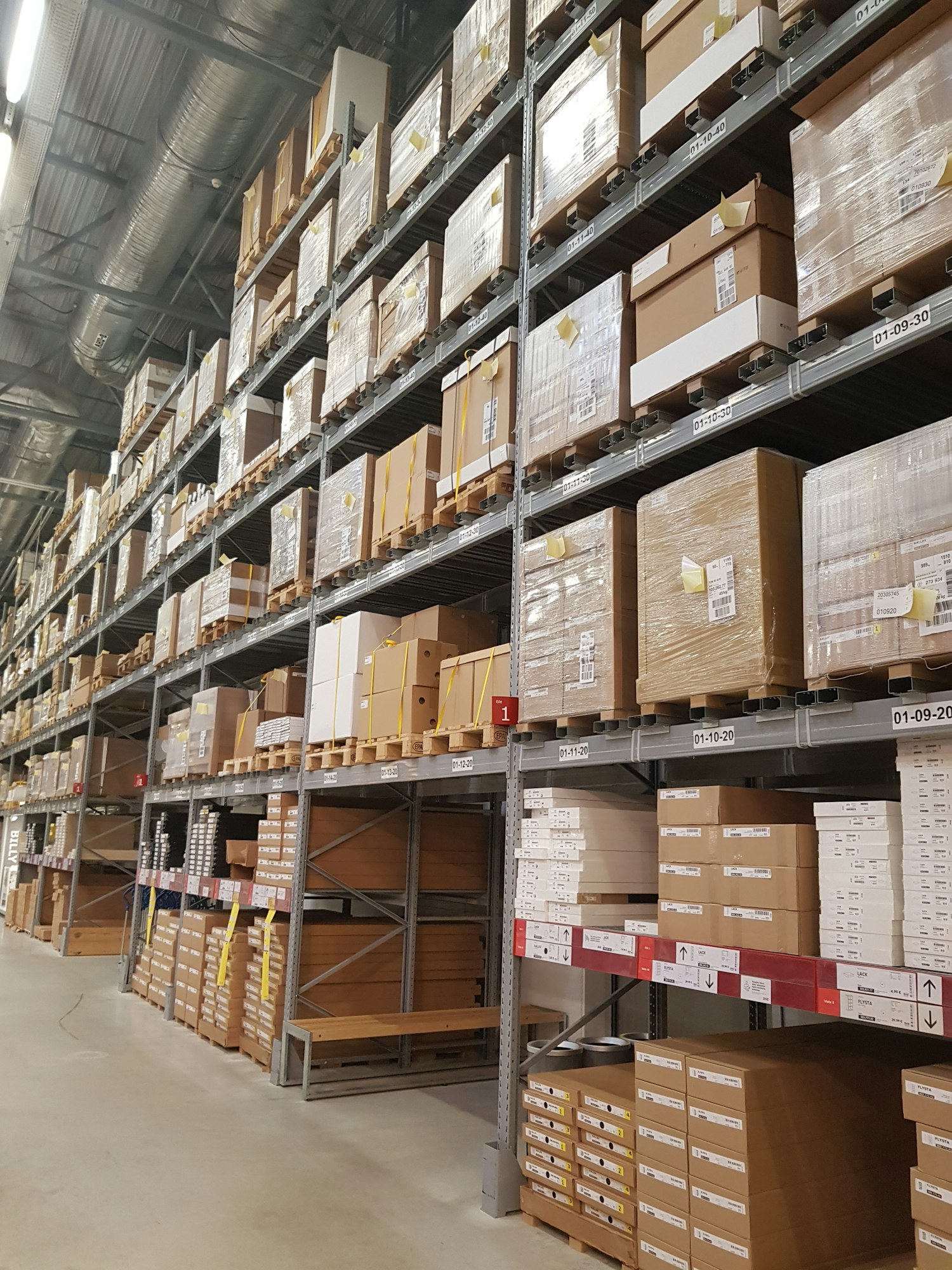 A spacious warehouse filled with shelves stacked high with numerous boxes, showcasing organized storage and inventory management.